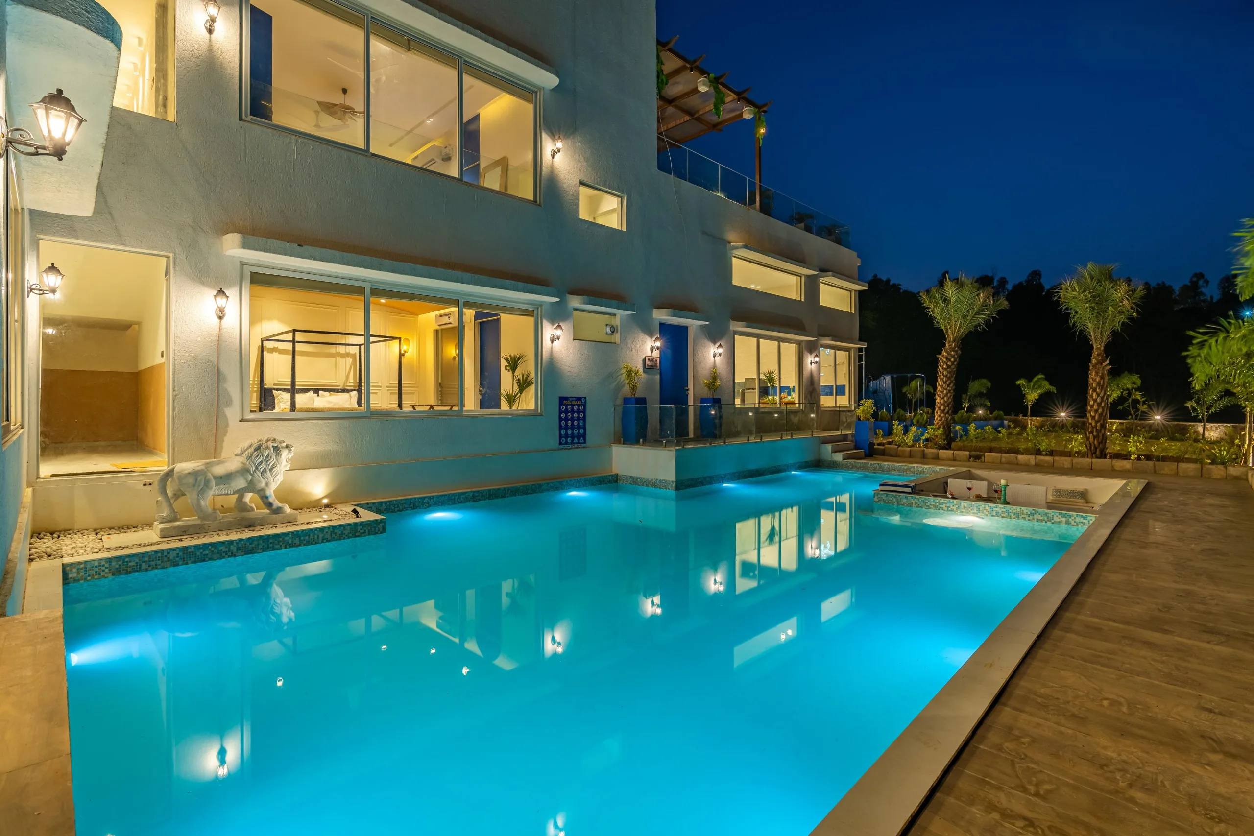 A villa and its lit pool on a clear evening