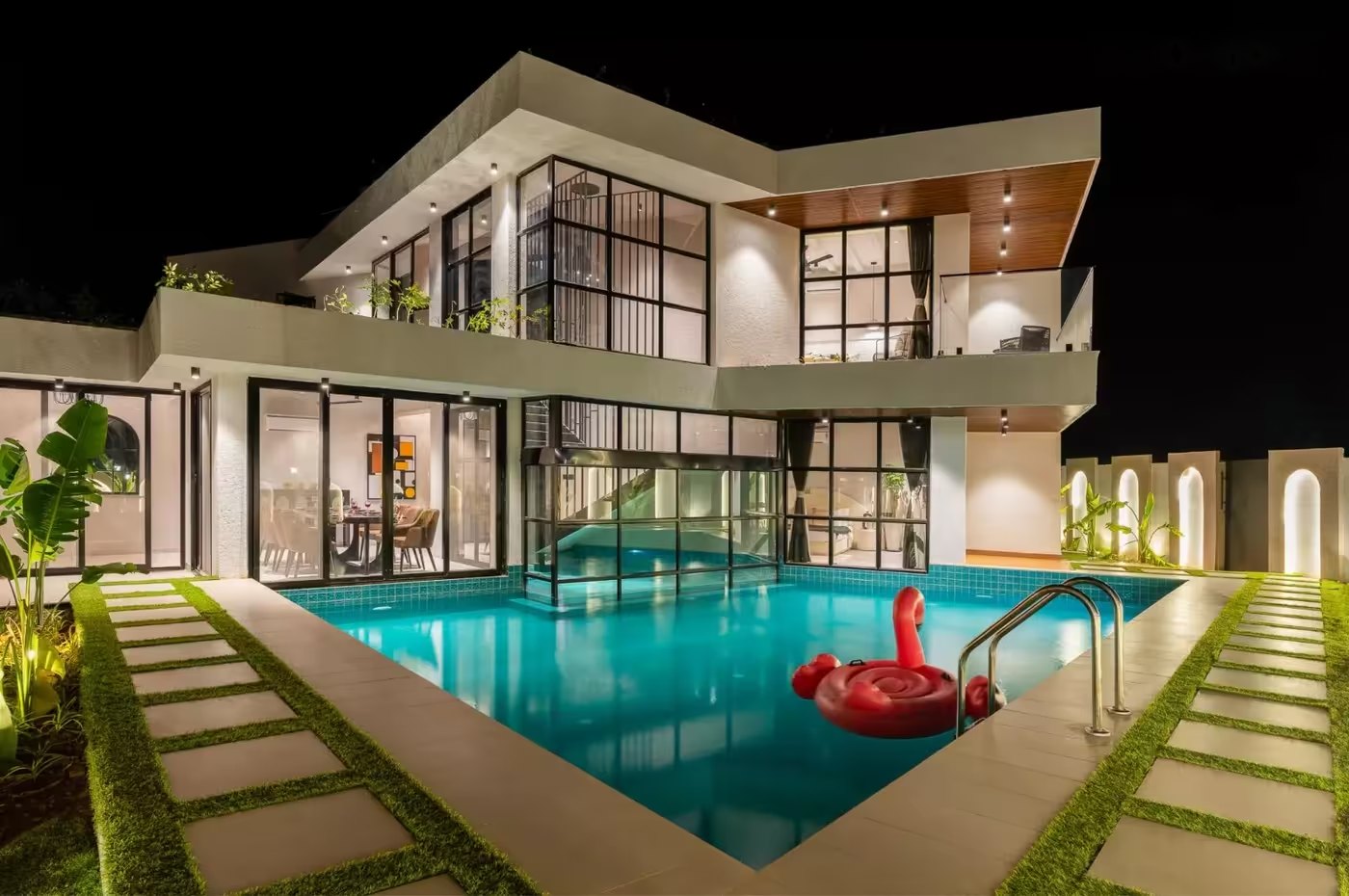 The house and pool lit up at night